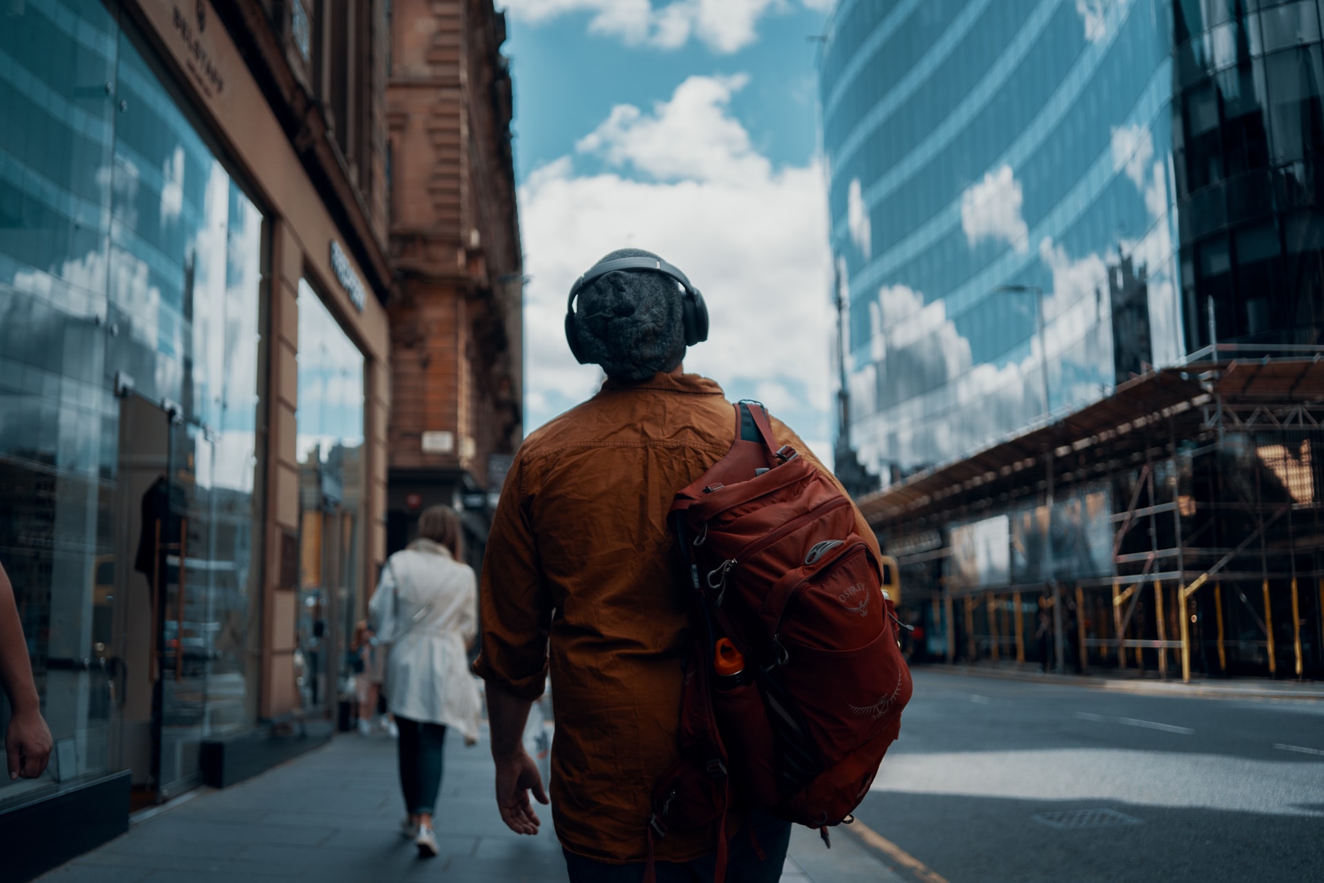 a man wearing headphones walking to work